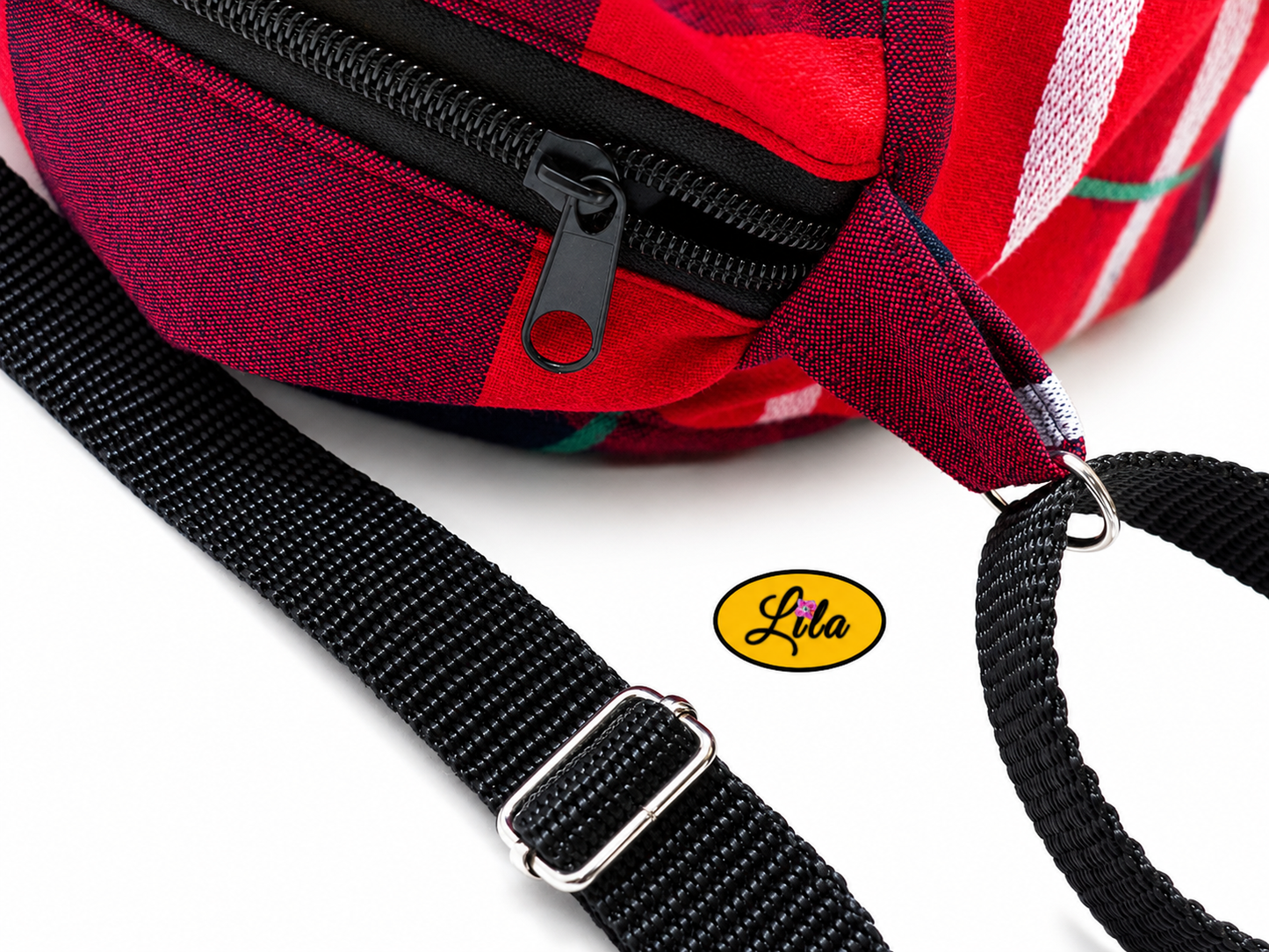 Zoom sur la fermeture éclair et les sangles du sac bandoulière en tartan rouge détail finition et qualité
