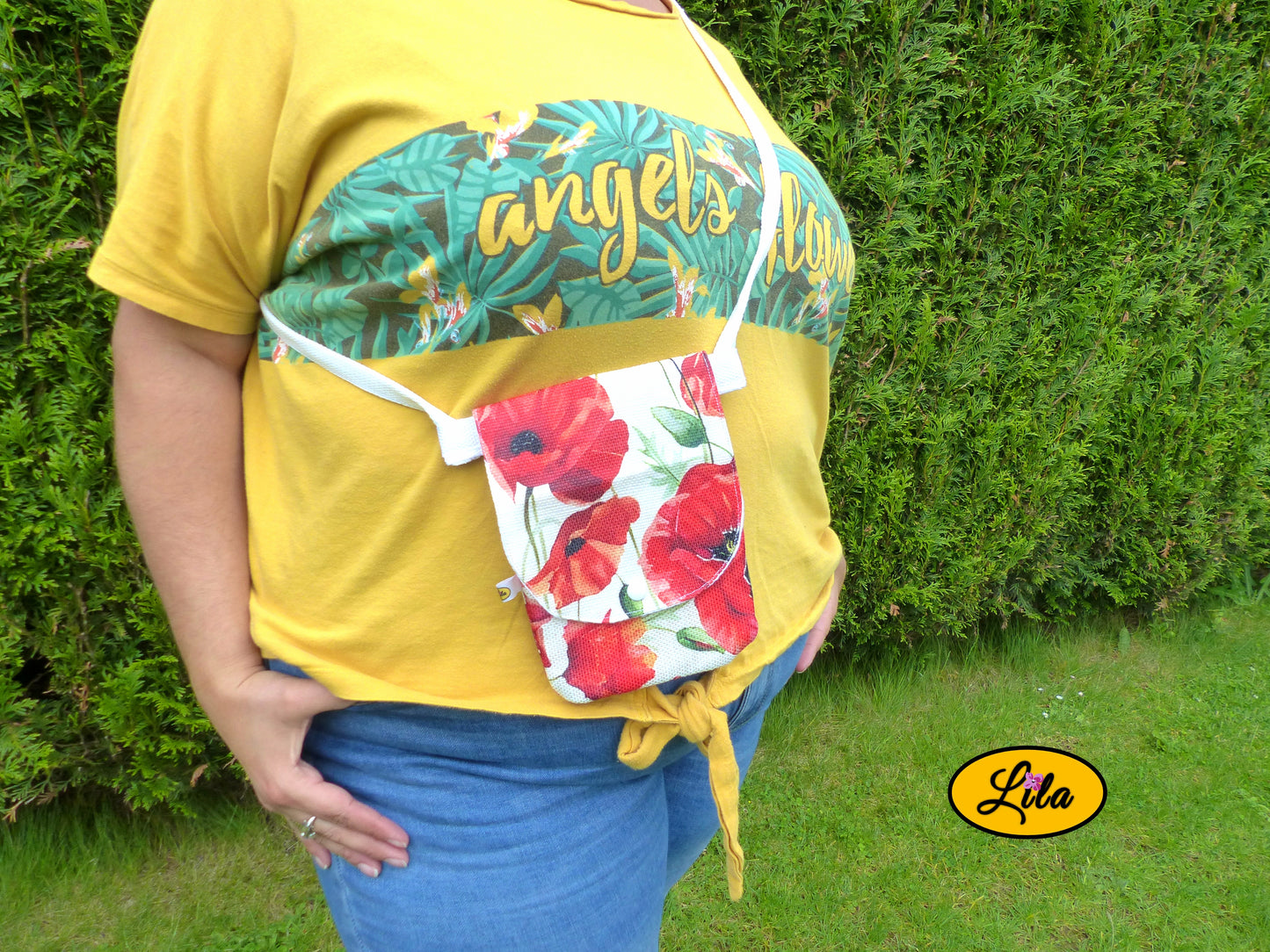 Sac bandoulière pour téléphone en tissu à motifs de coquelicots porté par une jeune femme dans un jardin devant une haie avec photo cadrée sur le sac mettant en valeur son format compact et son utilisation au quotidien