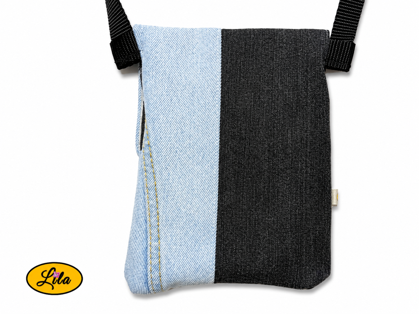 Vue arrière en gros plan d'un sac bandoulière pour téléphone en jeans bleu ciel avec bande noire au dos sans les sangles sur fond blanc mettant en valeur les finitions artisanales