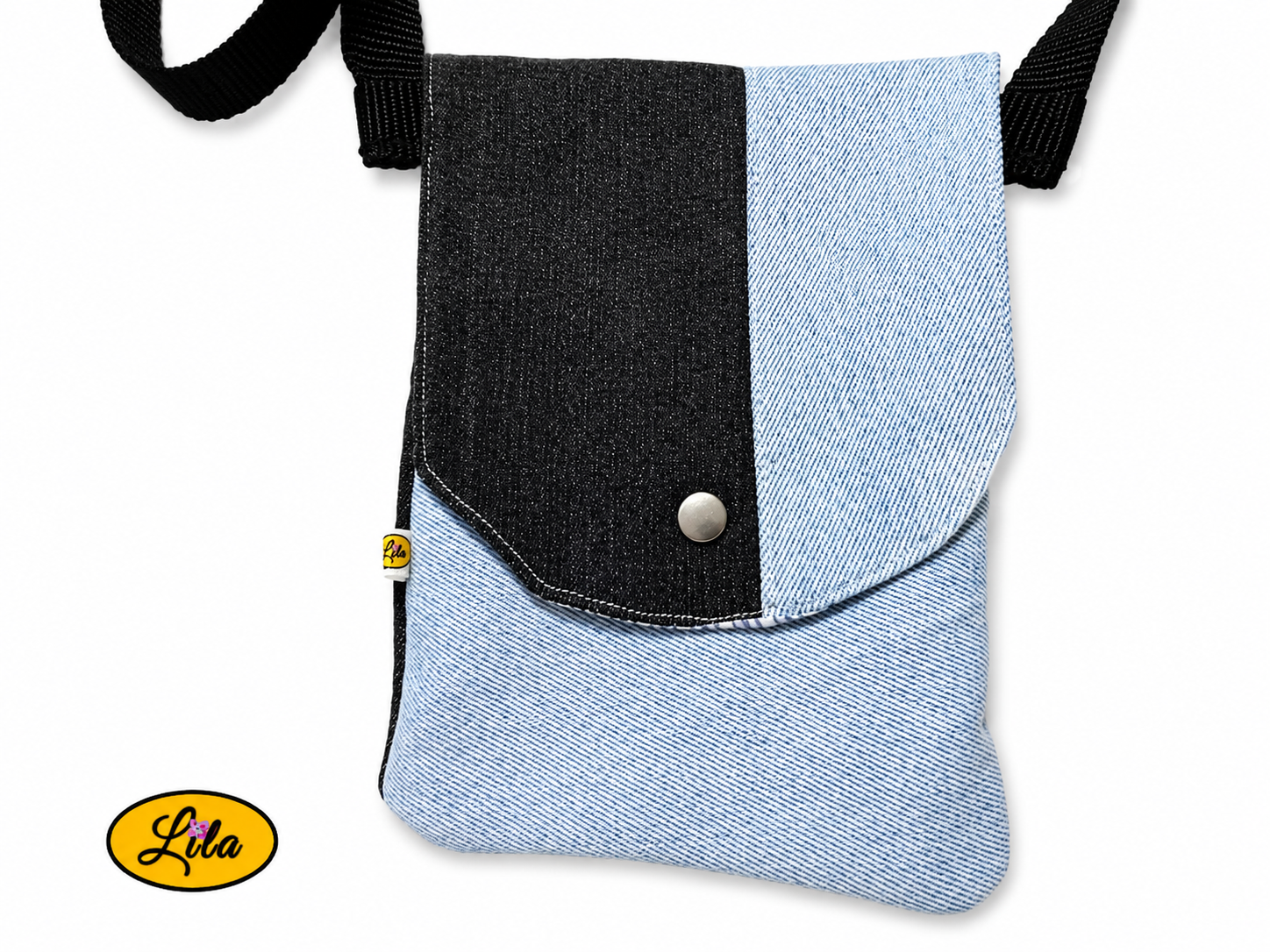 Zoom sur un sac bandoulière pour téléphone en jeans bleu ciel avec bande noire sur le rabat fermé sans les sangles sur fond blanc mettant en valeur les finitions et la fermeture à pression argentée