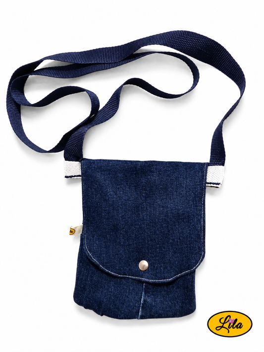Sac bandoulière pour téléphone en jeans bleu vu de haut sur fond blanc avec fermeture à pression argentée et sangle bleue style artisanal et pratique