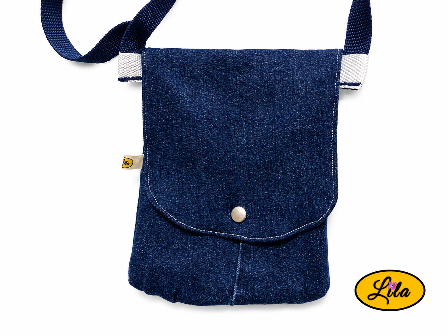 Zoom sur un sac bandoulière pour téléphone en jeans bleu fermé sans les sangles sur fond blanc avec fermeture à pression argentée mettant en valeur les finitions artisanales