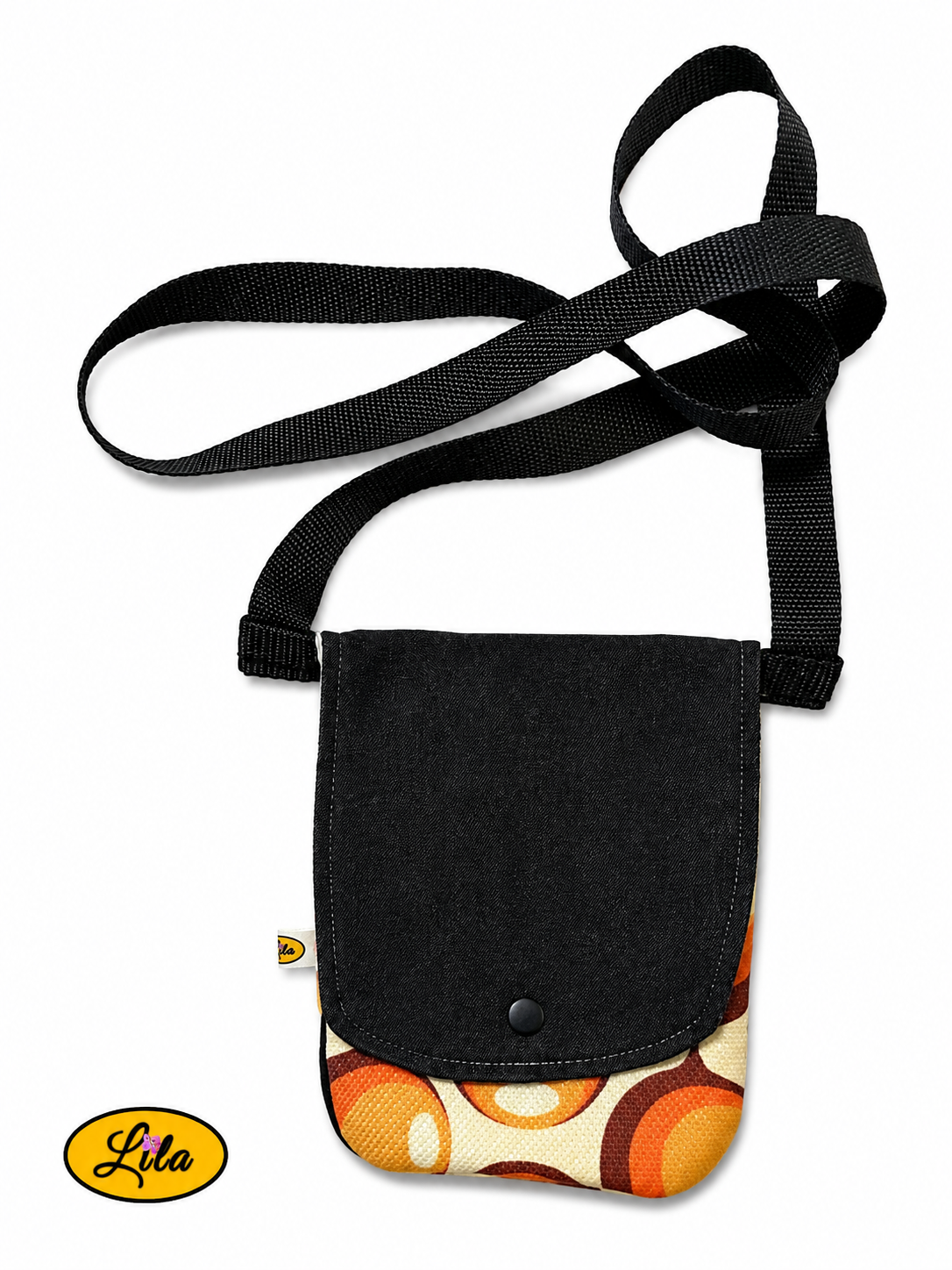 Sac bandoulière pour téléphone en jeans noir avec rabat en tissu vintage à motifs de ronds orange vu de haut sur fond blanc, fermeture à pression blanche et sangle en coton blanc, création artisanale
