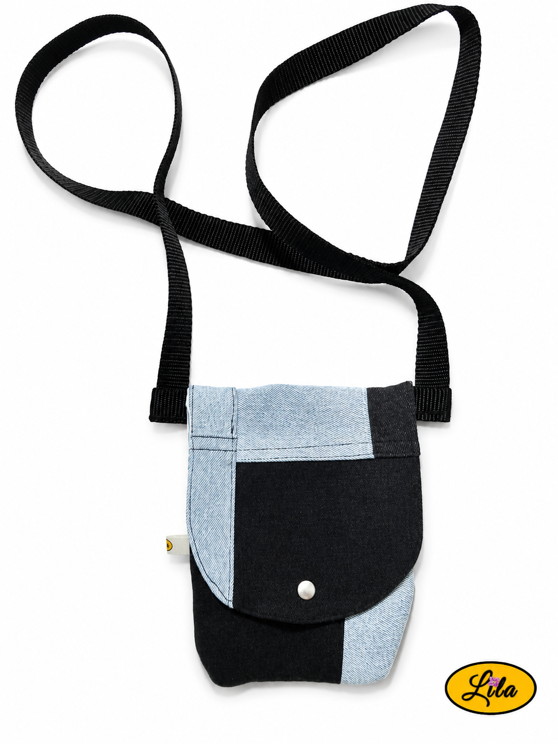 Sac bandoulière pour téléphone en patchwork de jeans recyclés bleu clair et noir vu de haut sur fond blanc avec fermeture à pression argentée et sangle noire style artisanal et écoresponsable