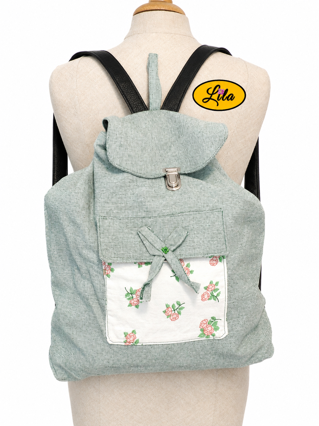 Sac à dos vert avec poche fleurie porté sur mannequin sur fond blanc style pratique et tendance