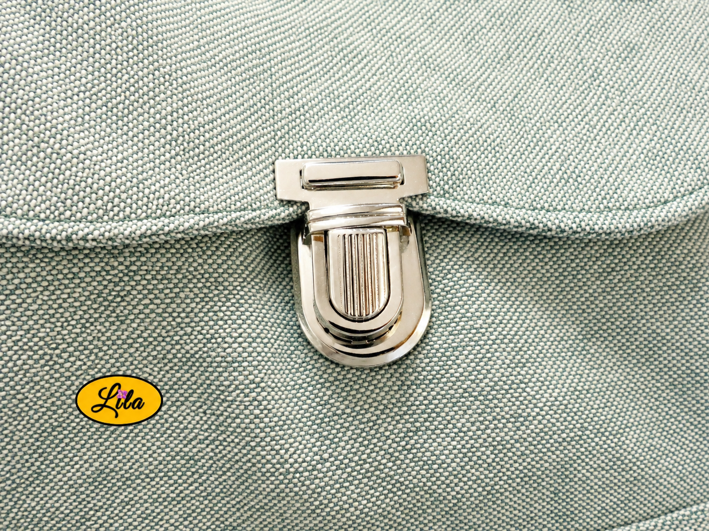Zoom sur la fermeture style cartable du sac à dos vert détail finition et attache