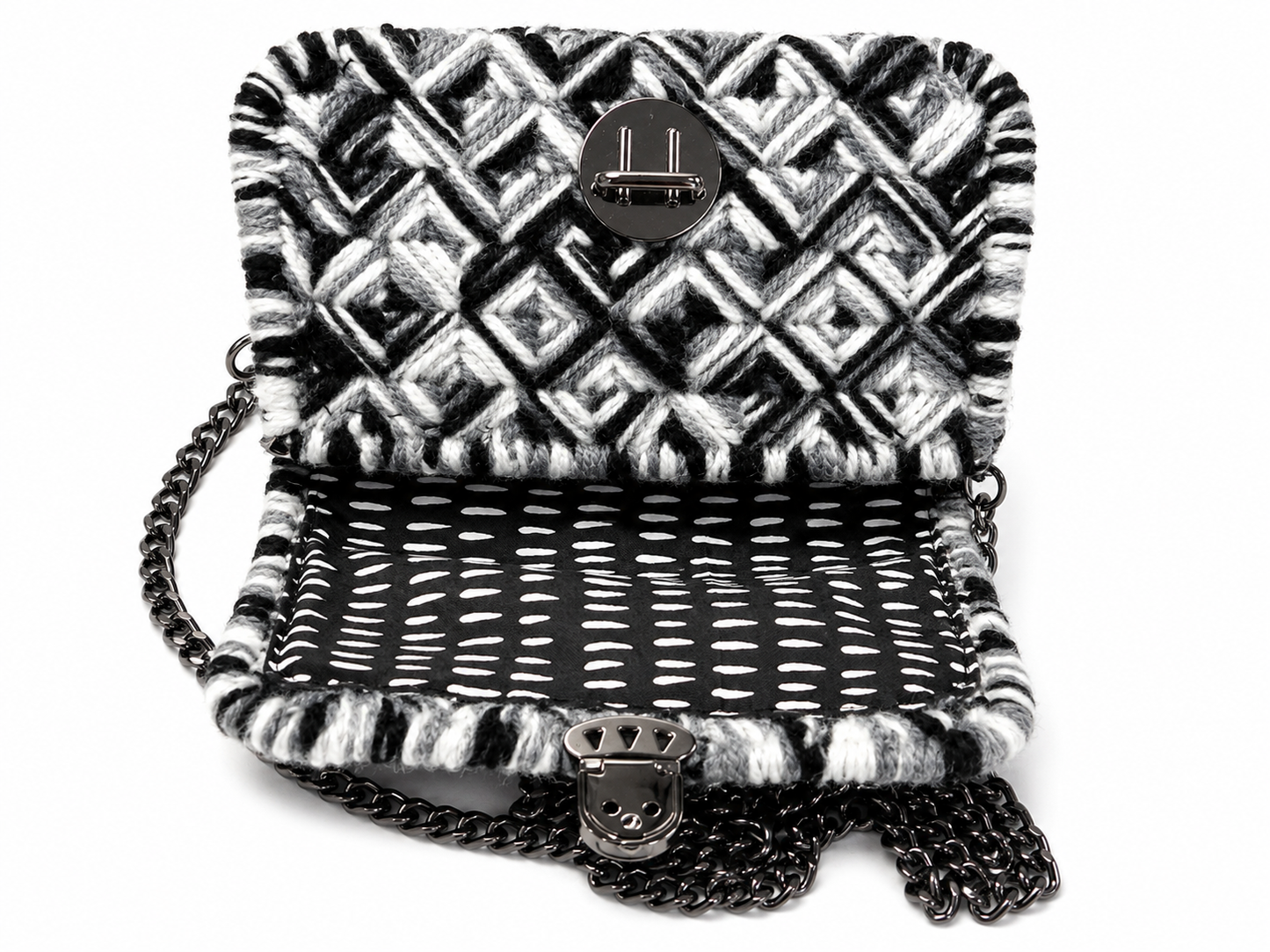 Sac graphique noir et blanc sur canevas rigide ouvert sur fond blanc avec doublure noir et blanc, attache cartable argentée et chaîne visible sur le dessus du sac
