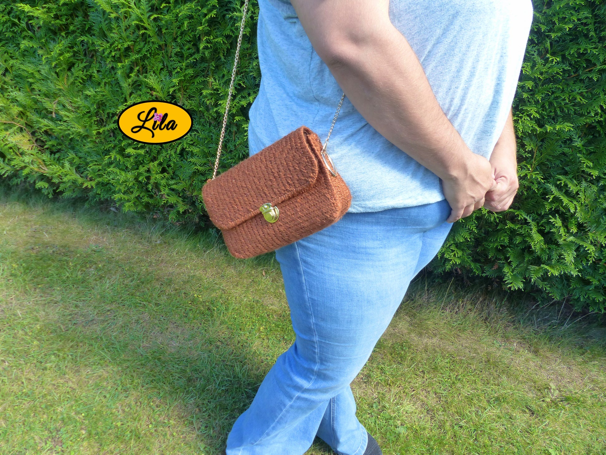 Sac en laine brun pailleté sur canevas rigide porté à l’épaule par un mannequin de profil en extérieur photo cadrée sur le sac style élégant et moderne