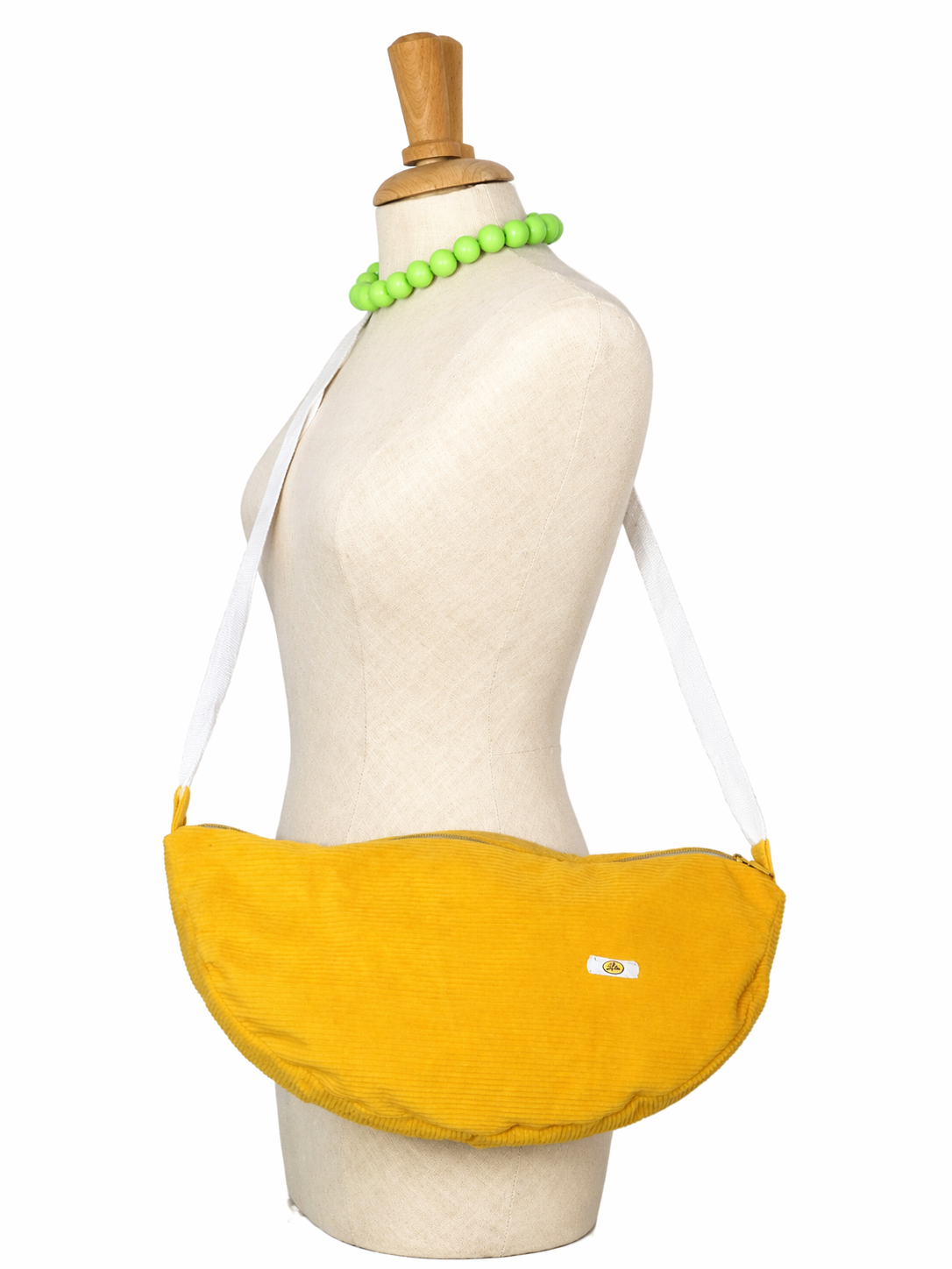 Sac Luna en velours jaune porté sur mannequin de profil montrant la longueur de l’anse