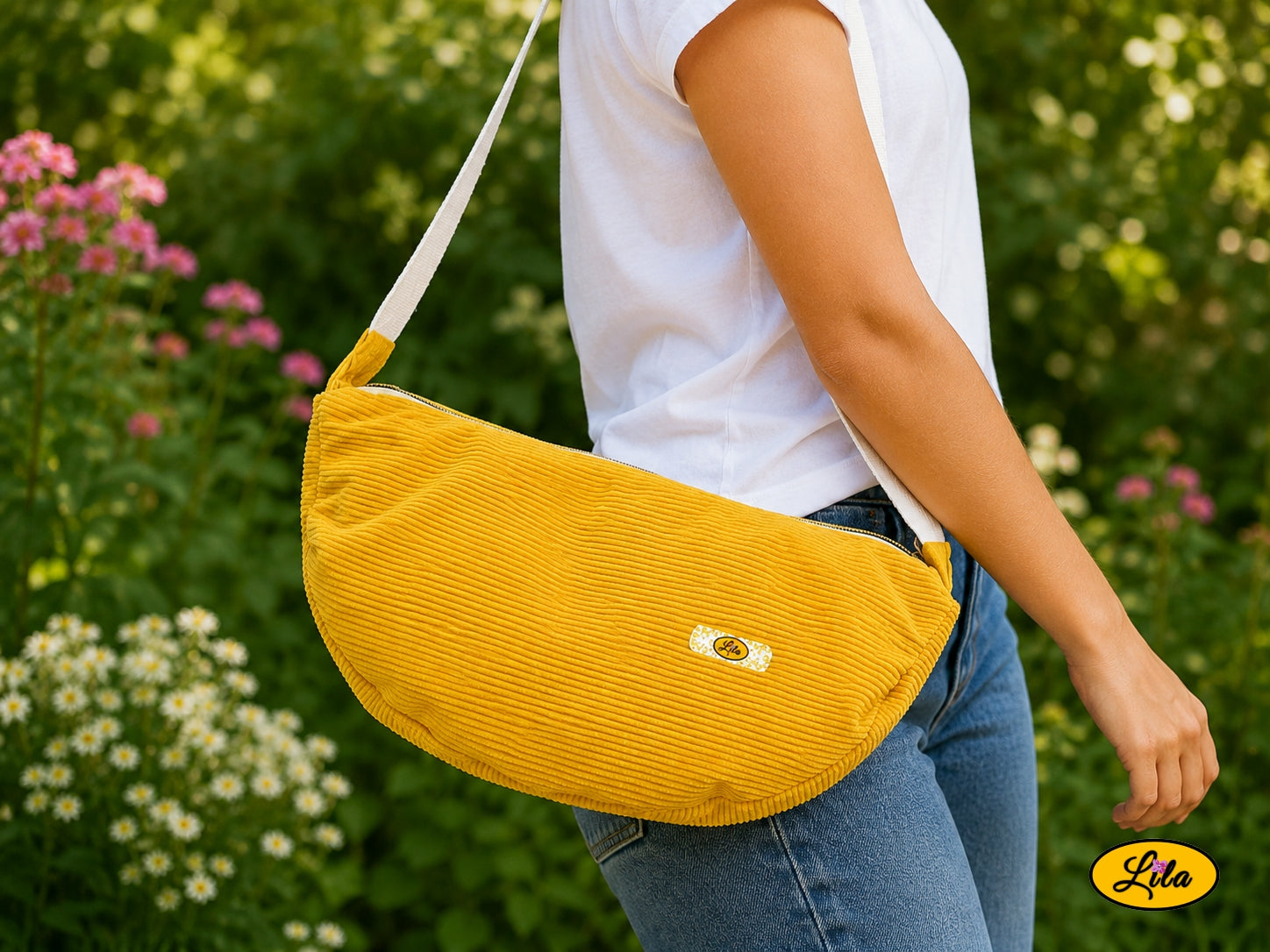 Sac Luna jaune en velours côtelé porté à l’épaule par un mannequin en jeans et t-shirt en extérieur photo cadrée sur le sac style moderne et lumineux