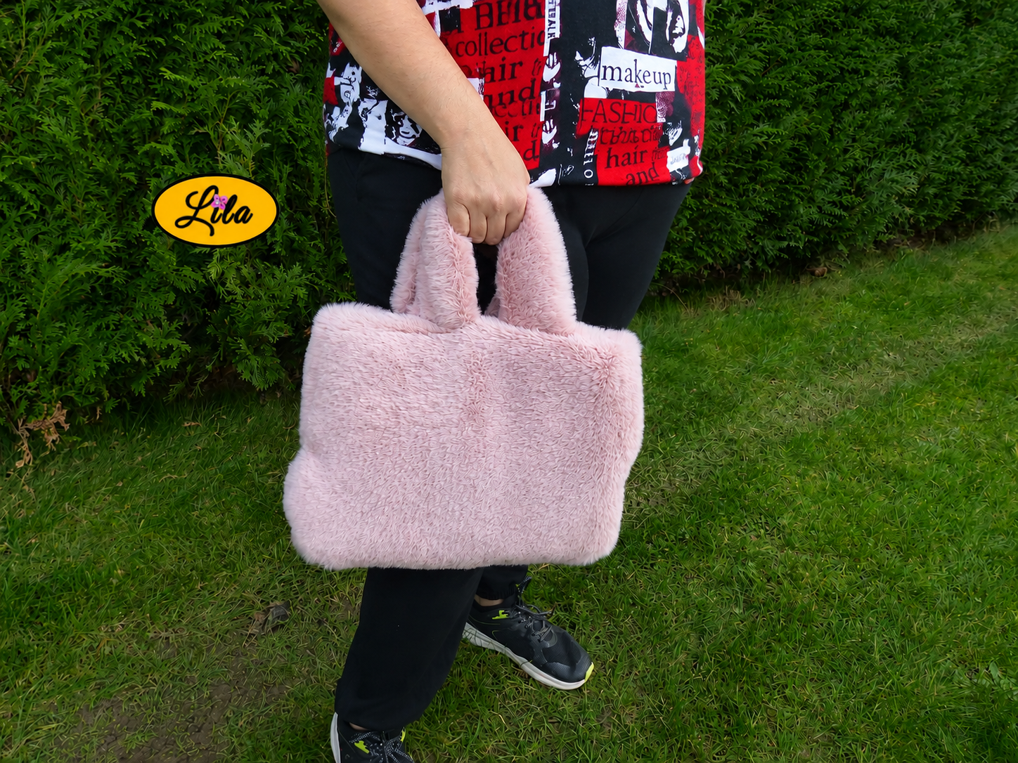 Sac à main entièrement en fausse fourrure vieux rose avec anses assorties porté à la main par un mannequin en extérieur photo cadrée sur le sac style chic et cocooning