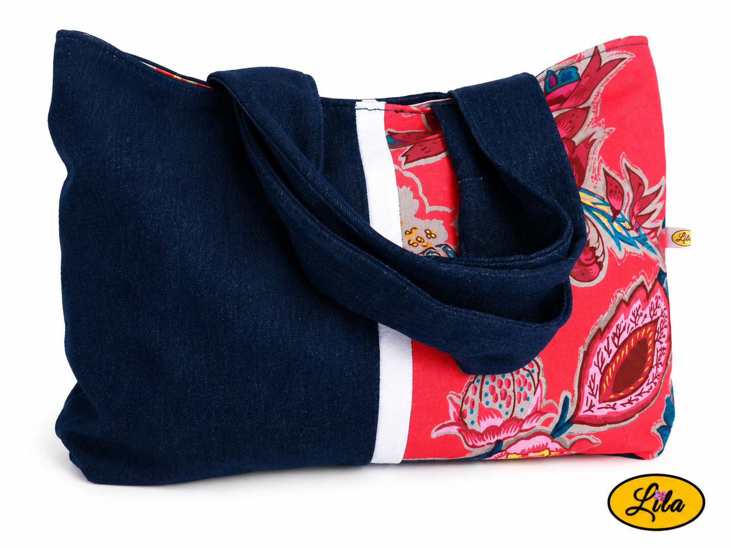 Sac à main en jeans et tissu floral rose vue de face sur fond blanc avec sangle posée sur le sac