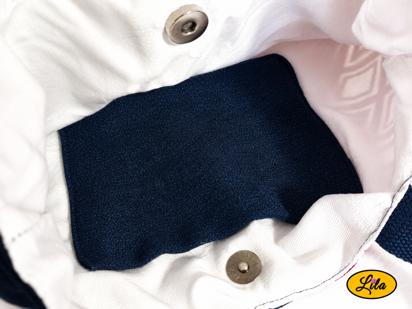 Zoom sur l’intérieur du sac à main en jeans et ancienne nappe rouge et blanche géométrique avec doublure blanche, poche en jeans et fermeture par attache pression
