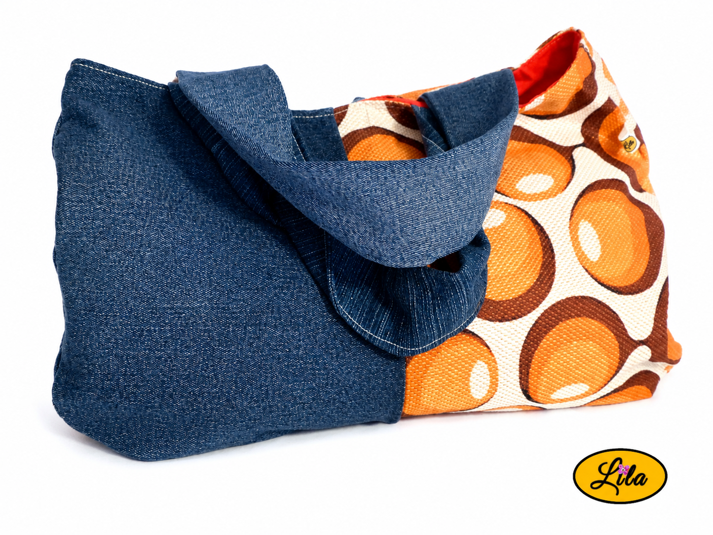 Sac à main en jeans et ancienne nappe vintage à ronds orange vue de face sur fond blanc avec sangles posées sur le sac