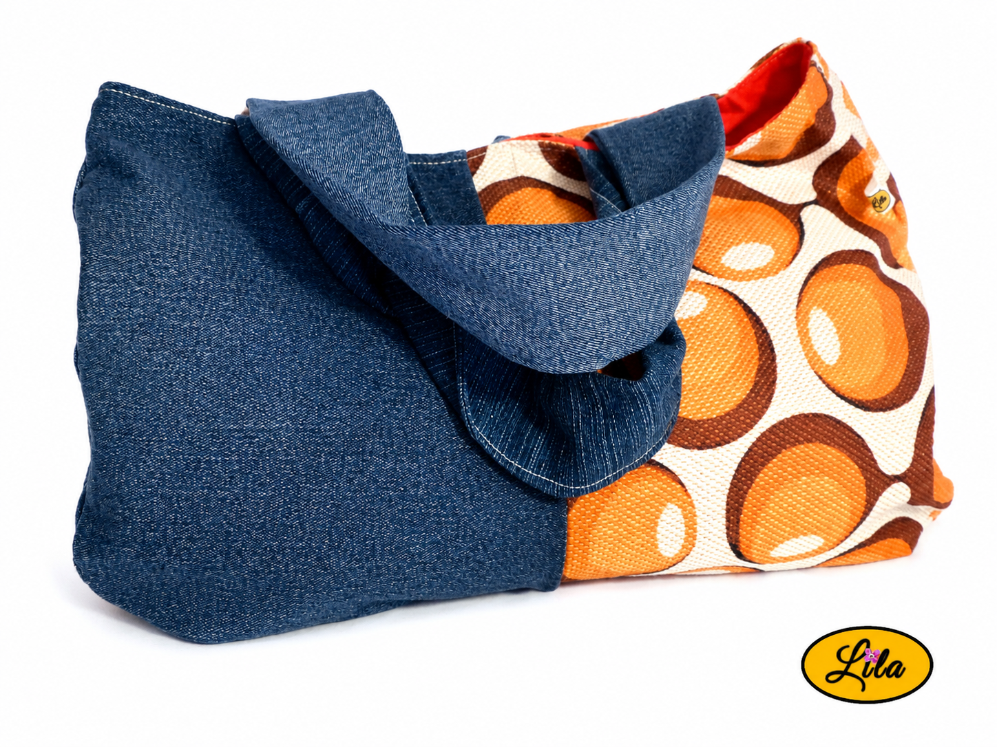 Sac à main en jeans et ancienne nappe vintage à ronds orange vue de face sur fond blanc avec sangles posées sur le sac