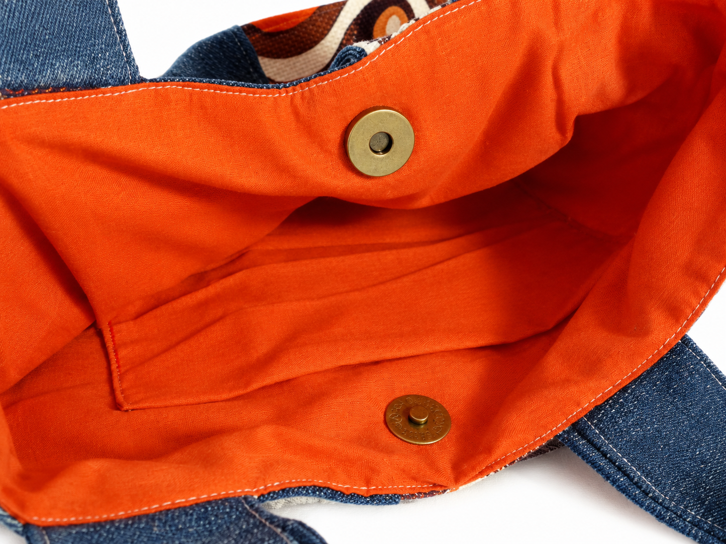Zoom sur l’intérieur orange du sac à main en jeans et tissu vintage à ronds orange avec poche assortie et fermeture par attache pression