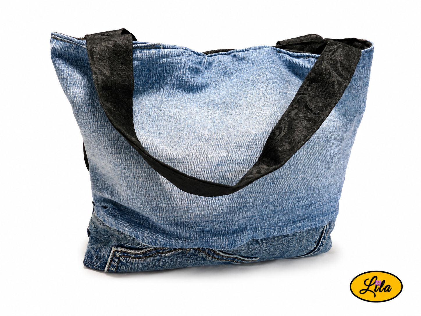 Sac en jeans recyclés bleu, bleu foncé et noir vu de face sur fond blanc avec une anse noire à motifs floraux visible style artisanal et écoresponsable