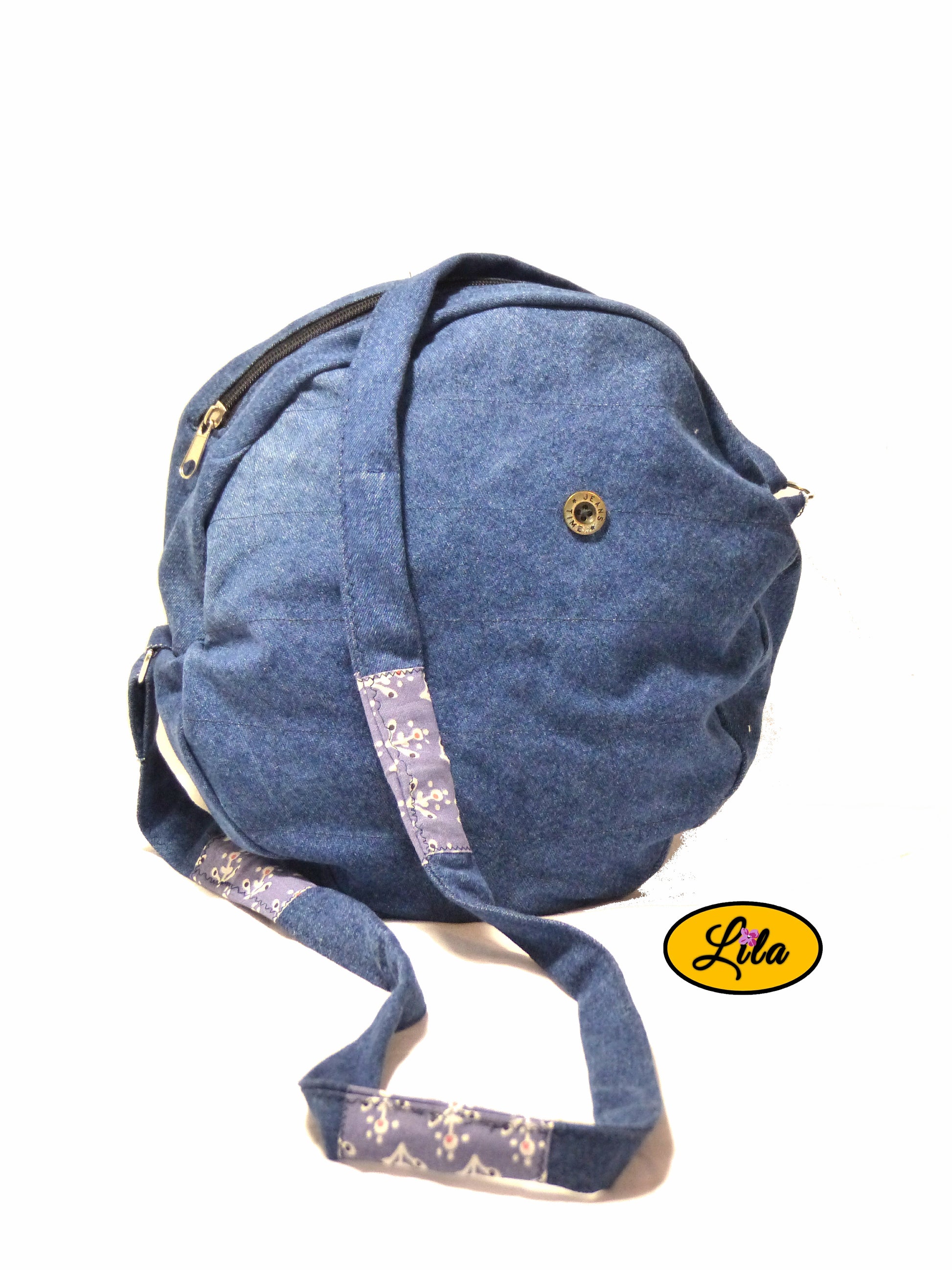 Sac rond en jeans vue de face avec bandoulière en jeans et détails en tissu assorti sur fond blanc