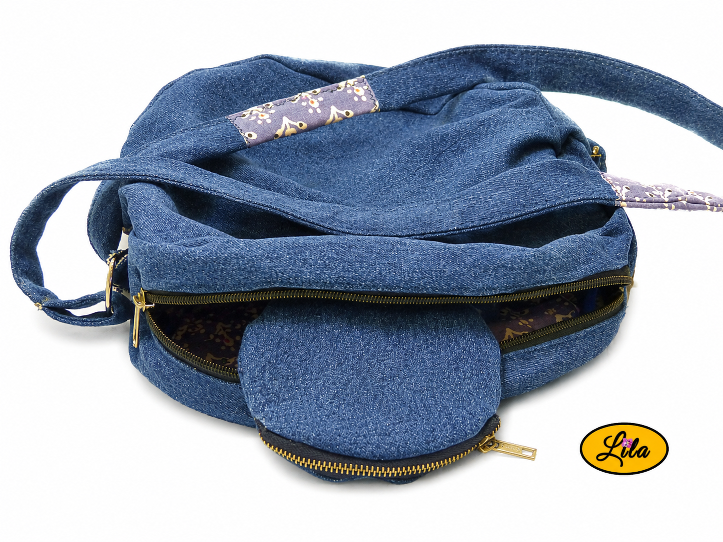 Sac rond en jeans ouvert à plat avec porte-monnaie assorti partiellement rangé à l’intérieur vue sur l’ouverture et les détails du sac