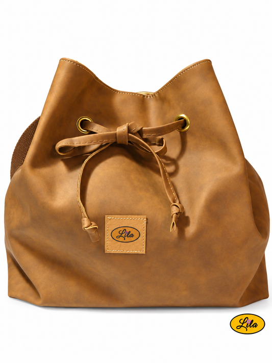 Sac seau en simili cuir brun doublé d'une ancienne tenture jaune à motifs imprimés, vu de face sur fond blanc avec lien coulissant formant un nœud, fermeture à pression et sangle bandoulière brune