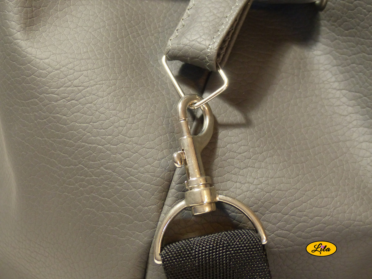 Zoom sur le crochet de fixation de la sangle noire récupérée sur le côté d'un sac seau en simili cuir gris, détail de finition artisanale