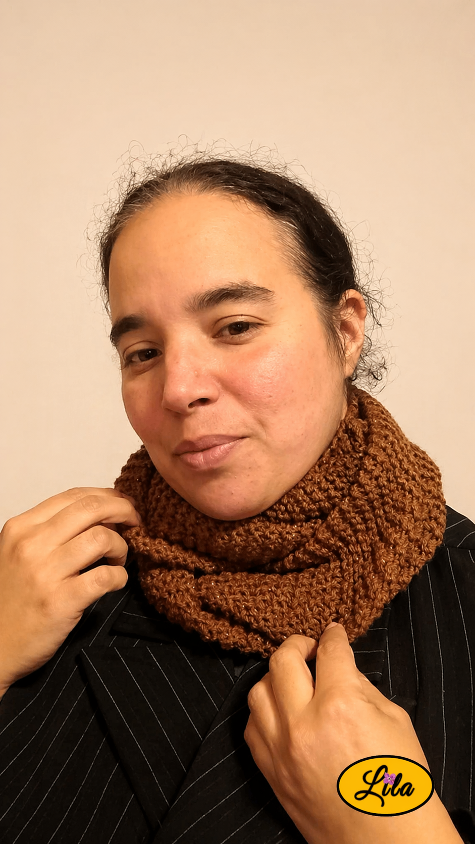 Snood en laine brun pailleté porté de face légèrement de profil gauche avec mains tenant le snood