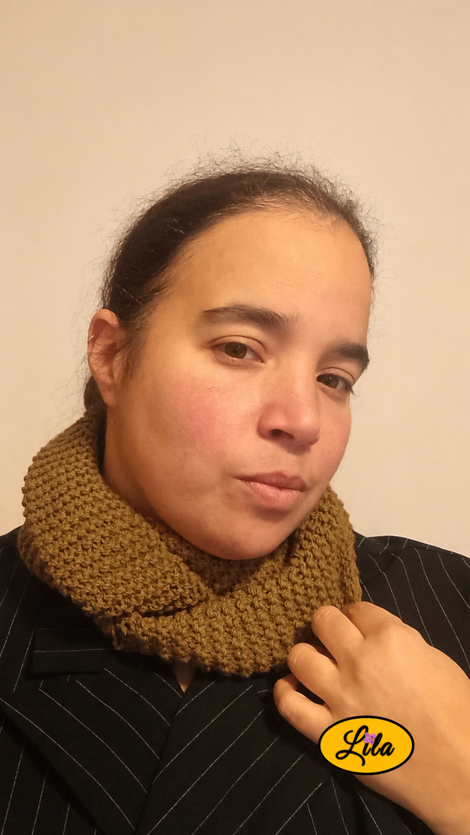 Snood en laine kaki porté profil droit avec une main ajustant le snood