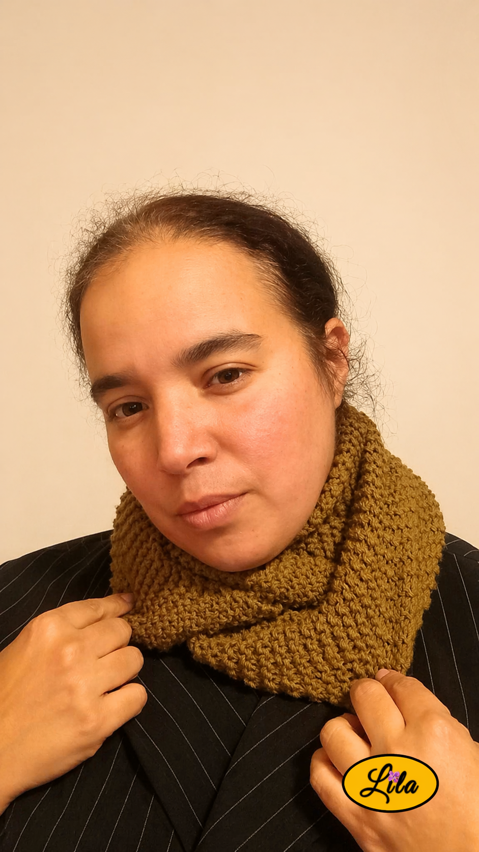 Snood en laine kaki porté profil gauche avec les deux mains tenant le snood