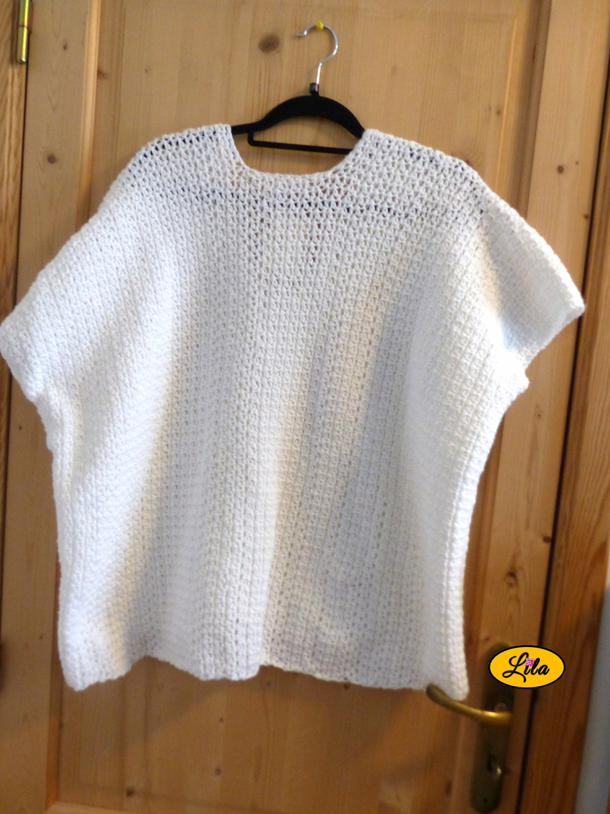 T-shirt blanc crocheté à la main en laine acrylique, taille 2XL, présenté sur cintre accroché à une porte, vue de dos