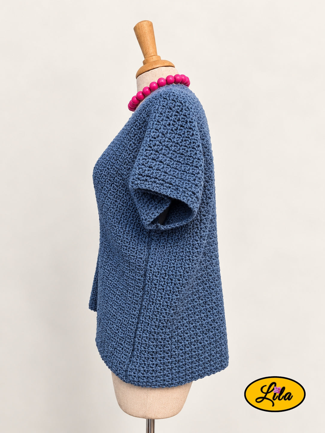 T-shirt bleu en crochet fait main en laine acrylique, taille M, vu de profil gauche sur mannequin de couture, mettant en valeur le point crocheté et la coupe du vêtement