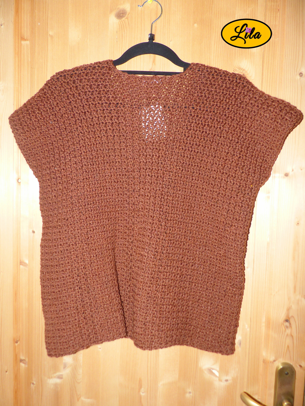T-shirt brun crocheté à la main en laine acrylique, taille M, présenté sur cintre accroché à une porte, vue de dos