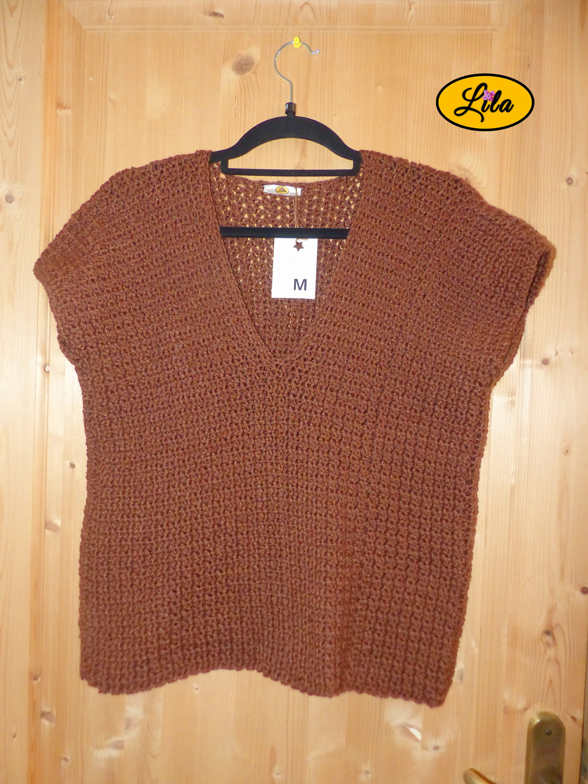 T-shirt brun crocheté à la main en laine acrylique, taille M, présenté sur cintre accroché à une porte, vue de face