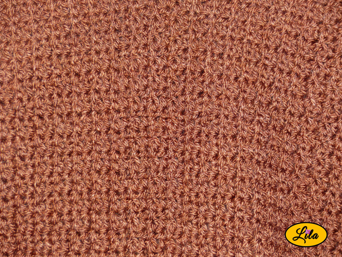 Zoom sur le point crocheté d'un t-shirt brun fait main en laine acrylique, taille M, mettant en valeur la texture et les détails du travail artisanal