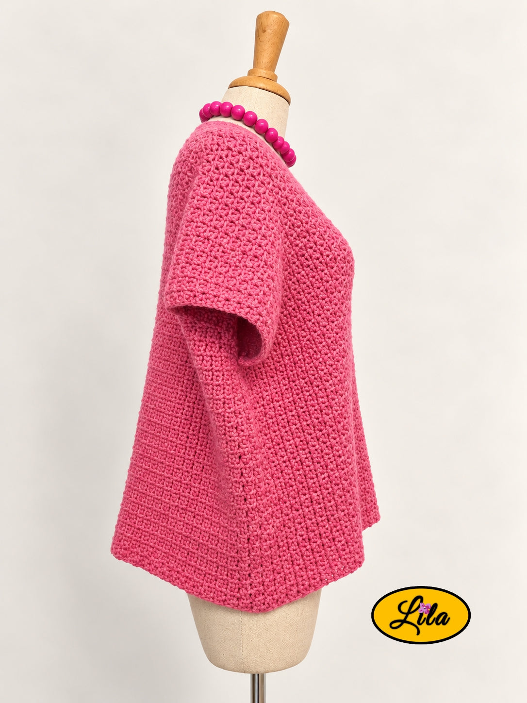 T-shirt rose en crochet fait main en laine acrylique, taille L, vu de profil droit sur mannequin de couture, mettant en valeur sa coupe et son travail au crochet