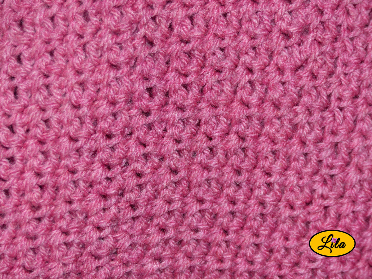 Zoom sur le point crocheté d'un t-shirt rose fait main en laine acrylique, taille L, mettant en valeur la texture et les détails du travail artisanal