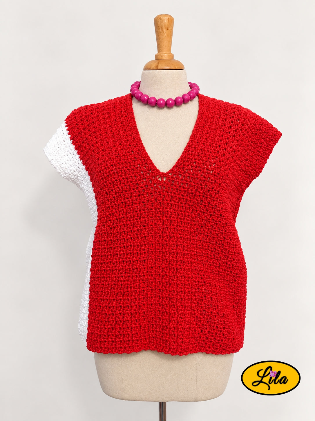 T-shirt rouge crocheté à la main en laine acrylique, taille S, avec bande blanche sur le côté droit, présenté de face sur mannequin de couture