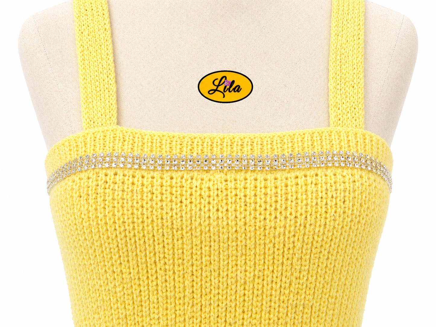 Zoom sur la partie poitrine du top Augustine jaune tricoté à la main porté sur mannequin de couture avec bande de strass cousue détail élégant et féminin