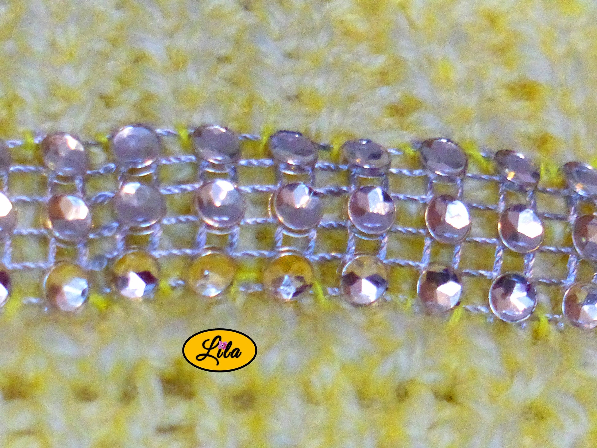 Zoom sur la bande de strass cousue au niveau de la poitrine du top Augustine jaune tricoté à la main détail brillant et élégant