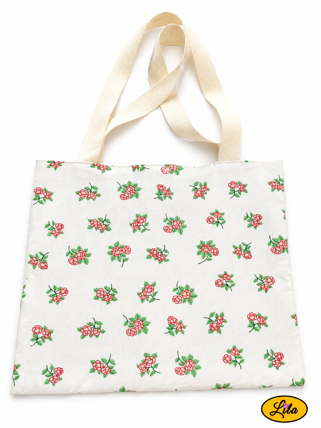 Tote bag en tissu blanc à motifs de petites fleurs roses vu à plat de haut sur fond blanc avec sangles blanc crème placées au-dessus du sac style romantique et artisanal