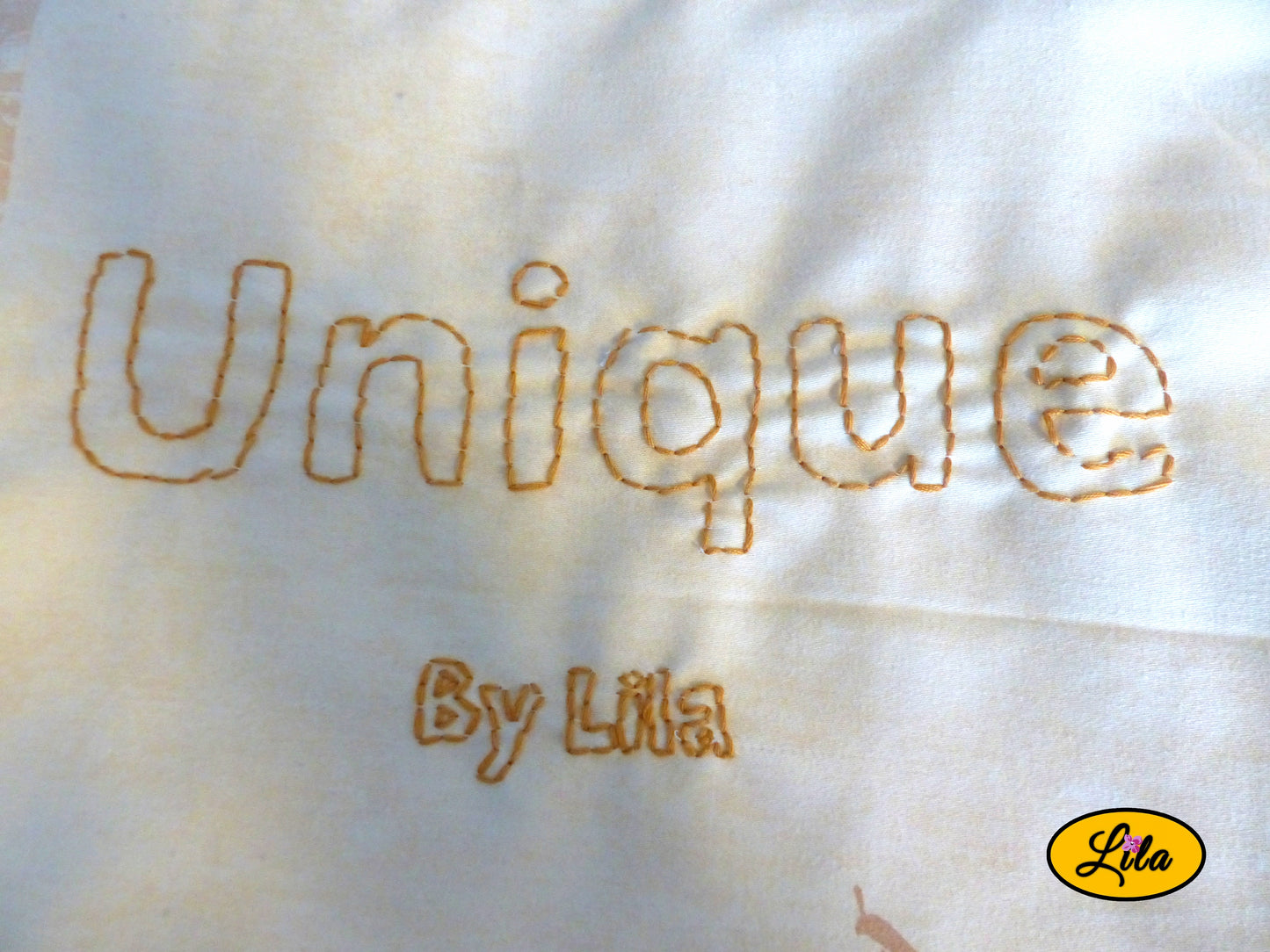 Zoom sur la broderie artisanale « UNIQUE by Lila » réalisée à la main sur un tote bag jaune style personnalisé et créatif