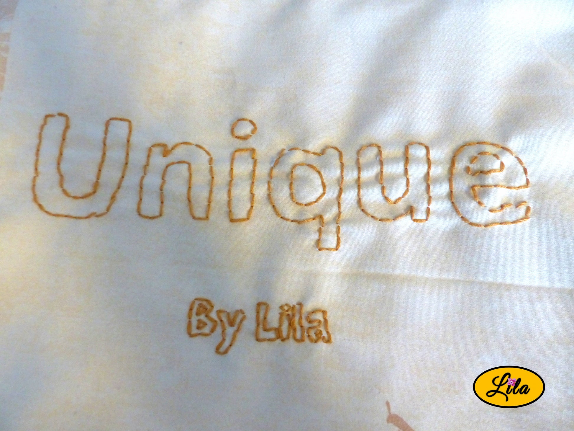 Zoom sur la broderie artisanale « UNIQUE by Lila » réalisée à la main sur un tote bag jaune style personnalisé et créatif