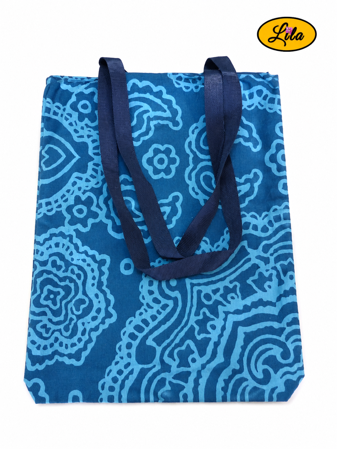 Tote bag en tissu bleu turquoise à motifs graphiques bleus vu de dos en vue de haut sur fond blanc avec les sangles posées sur le sac style contemporain et artisanal