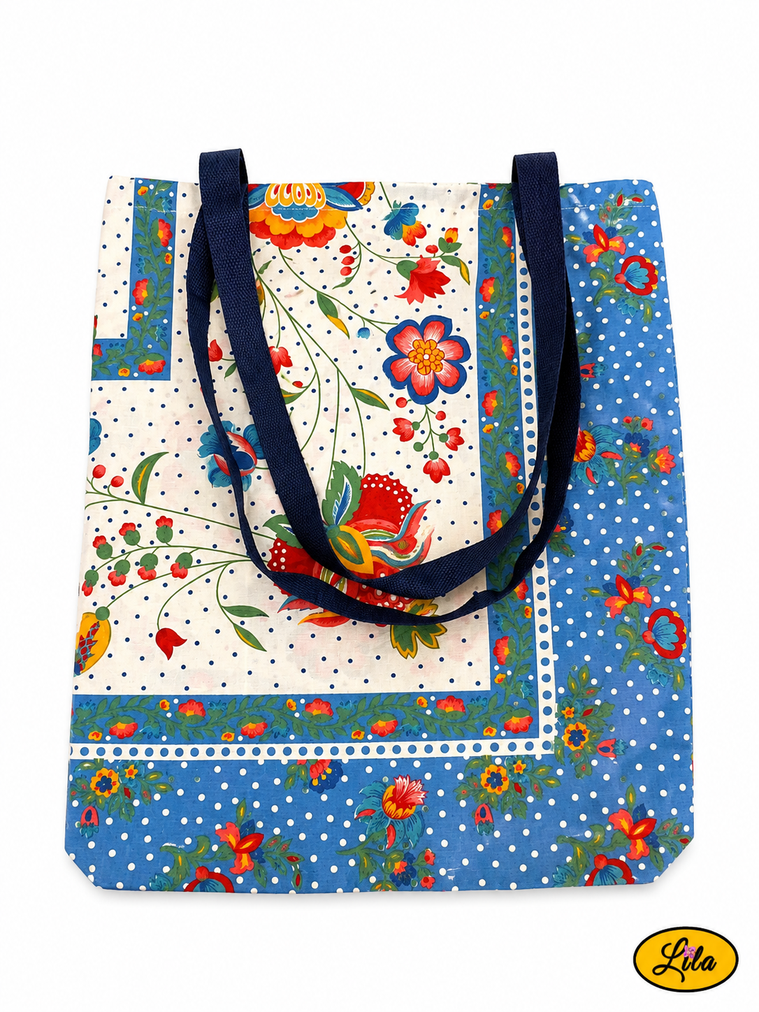 Tote bag en tissu vintage à motifs fleuris bleus vu de dos en vue de haut sur fond blanc avec les sangles bleues posées sur le sac style romantique et artisanal