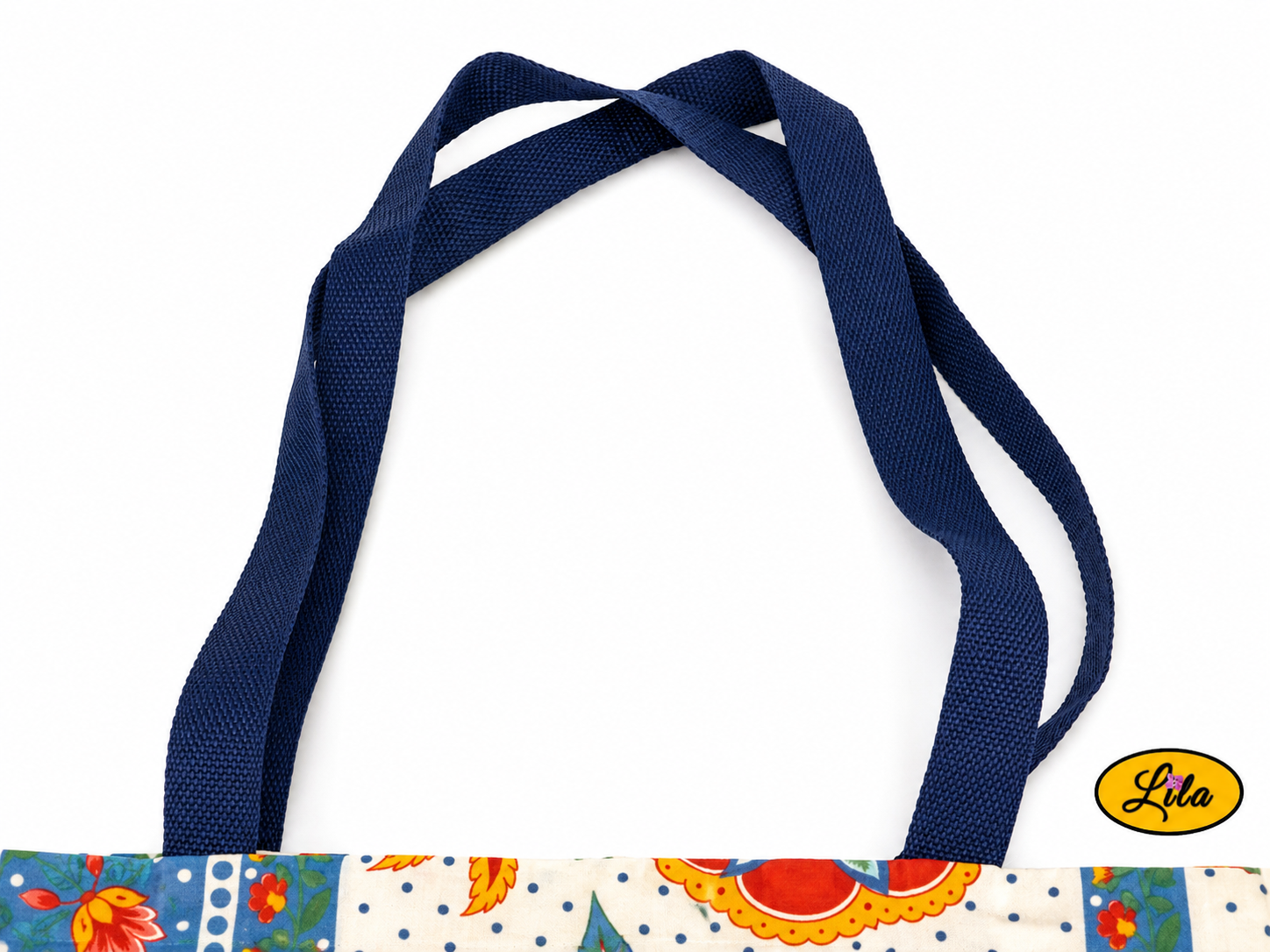 Zoom sur les sangles bleues d’un tote bag en tissu vintage à motifs fleuris bleus sur fond blanc style artisanal et soigné