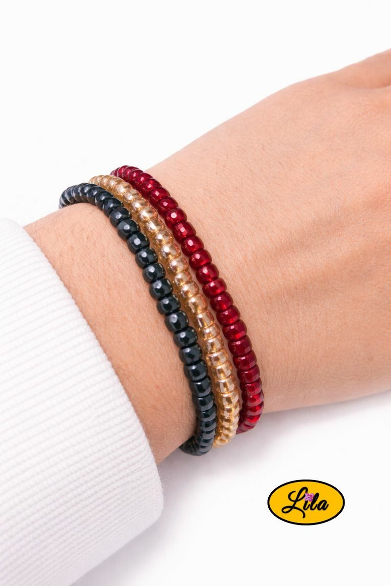 Trio de bracelets en perles carrées noir jaune et rouge brillant porté au poignet style moderne