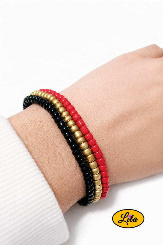 Trio de bracelets en perles carrées noir jaune et rouge mat porté au poignet style graphique