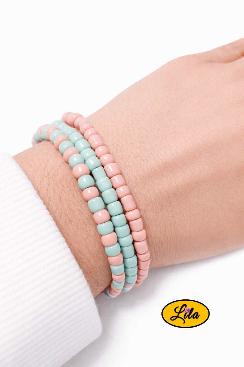 Trio de bracelets en perles carrées vertes et roses pastel porté au poignet style tendance