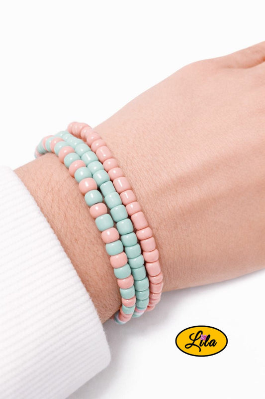 Trio de bracelets en perles carrées vertes et roses pastel porté au poignet style tendance