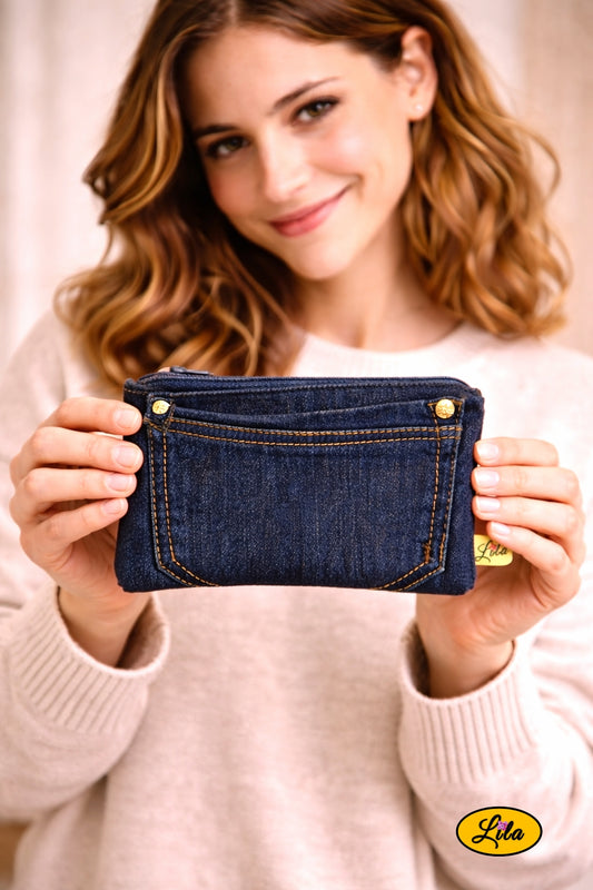 Trousse en jean foncé avec poche à l’avant tenue à deux mains face à l’objectif style pratique